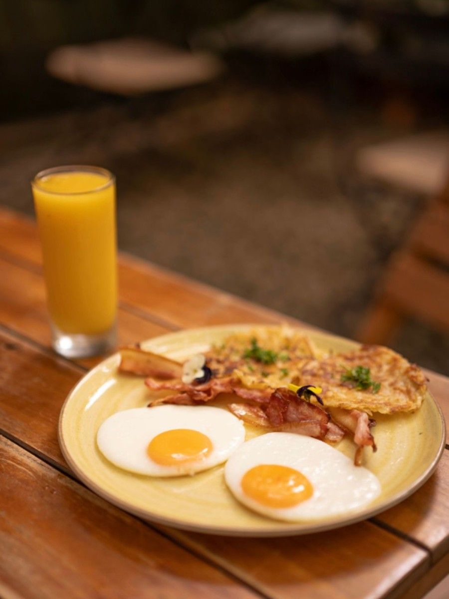 Rösti al estilo Berna en Bread Factory: rösti crocante con tocineta y dos huevos fritos, con un vaso de jugo